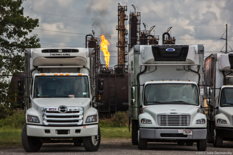 Trucks in front of flaring at ExxonMobil Beaumont plant after Hurricane Harvey