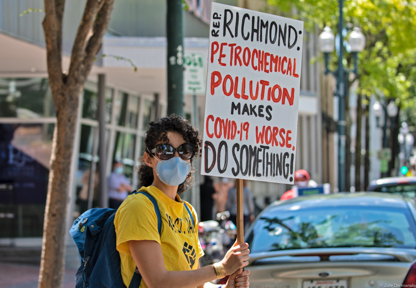 Activist holding a sign pressuring Cedric Richmond on petrochemical pollution in his district