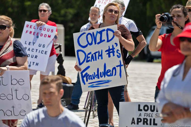 Woman with a COVID-19 denial sign at an "end the shutdown" rally in Baton Rouge