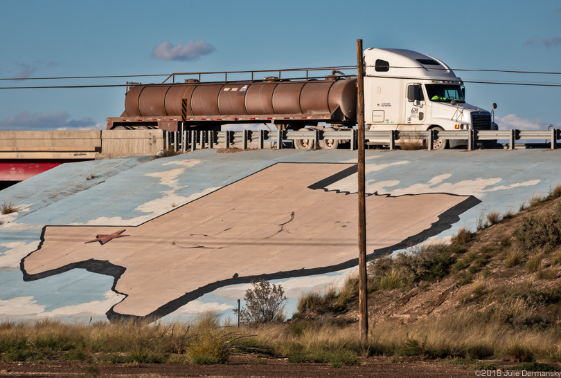 Fracking industry truck passes a mural of Texas