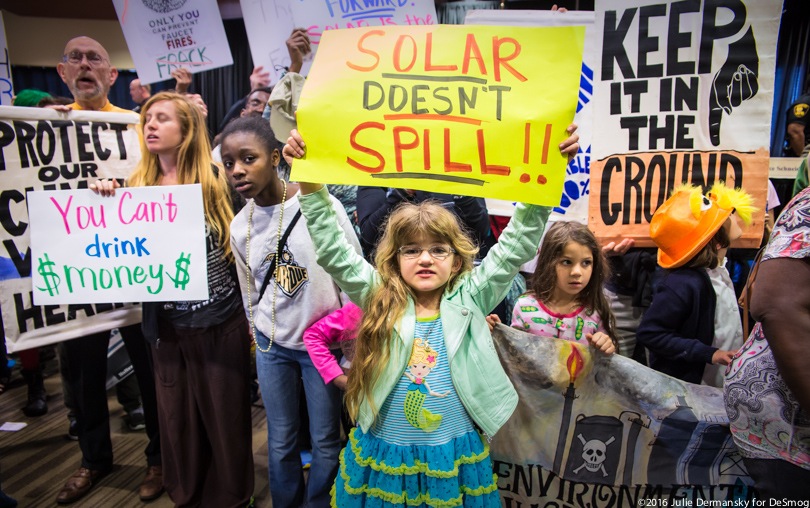 Children holding signs in a protest in the New Orleans Superdome against a federal auction of Gulf of Mexico drilling leases.