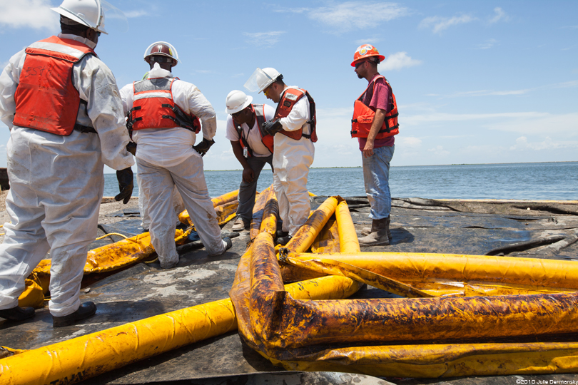 BP oil spill cleanup workers with oiled containment boom