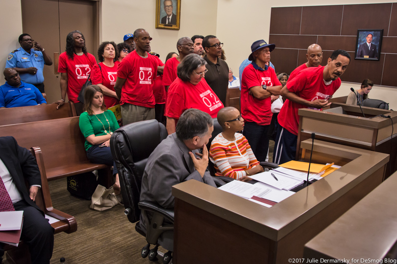 Wearing red t-shirts, members of the Concerned Citizens of St. John the Baptist Parish line up at a parish council meeting