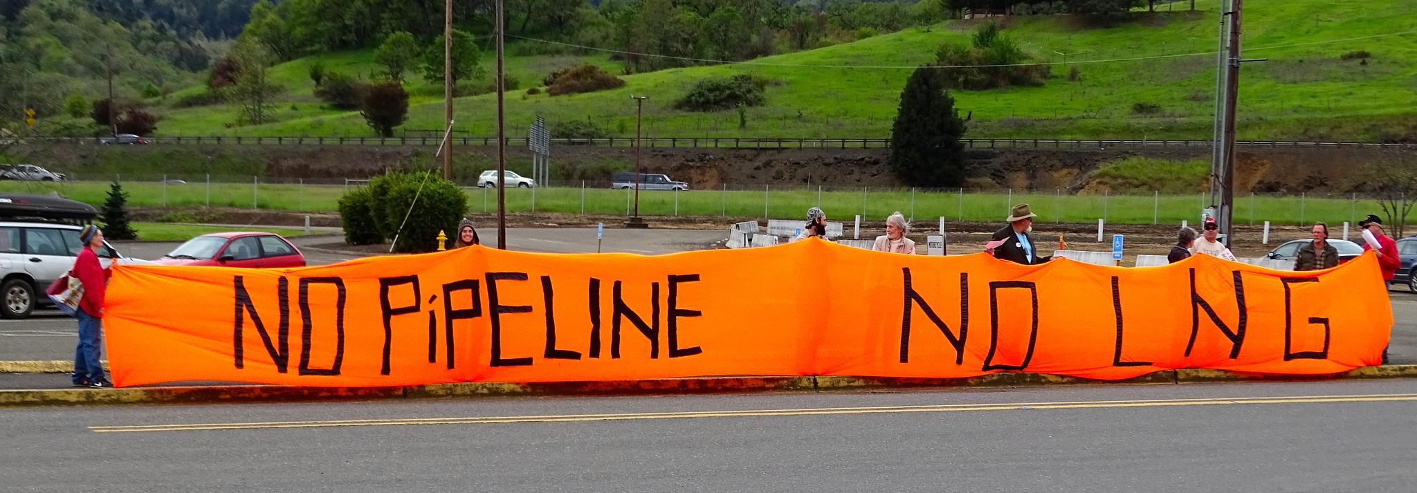 Jordan Cove LNG project protesters in Oregon hold an orange tube banner reading 'no pipeline - no LNG'