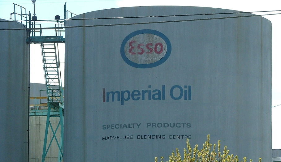 Large white industrial tank labeled 'Esso' and Imperial Oil specialty products' in blue and red paint