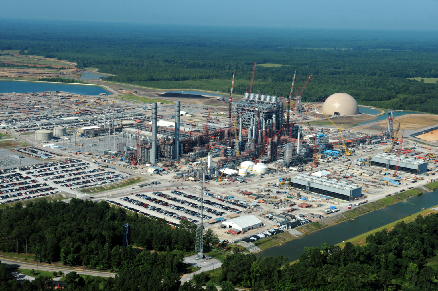 A massive coal gasification site under construction amid wooded areas