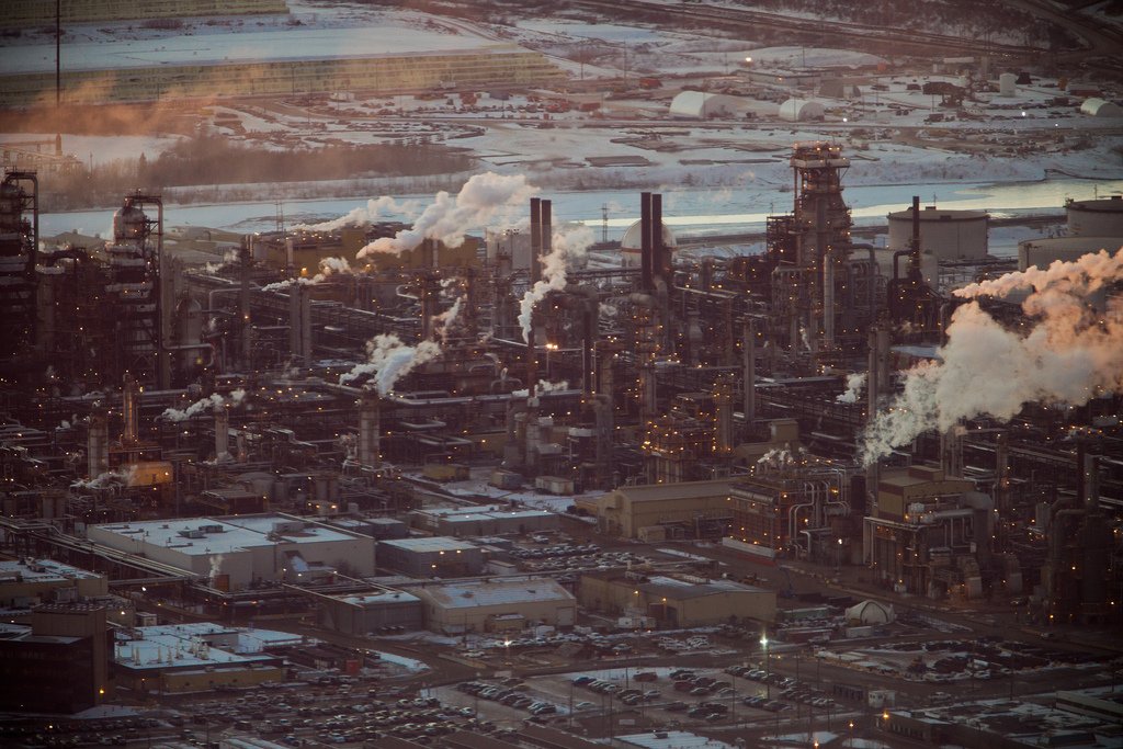 Fort McMurray, Alberta, Canada, oil sands refinery with smokestacks and snow in the background