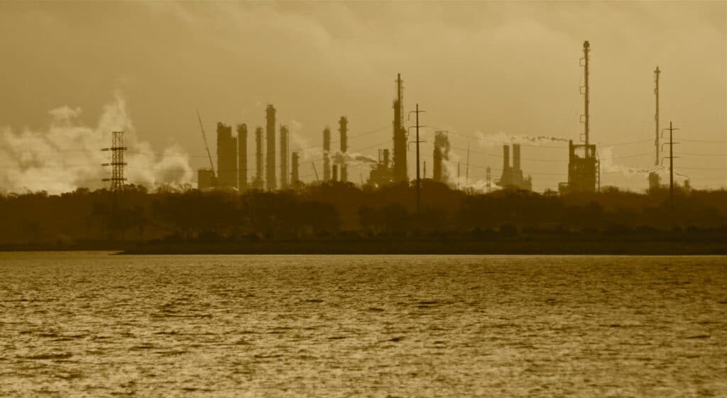 Oil refinery smokestacks release smoke at twilight along the Gulf Coast
