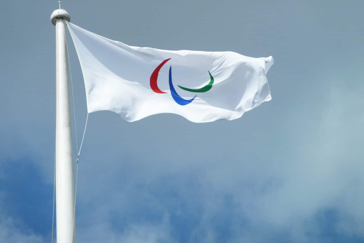 A white flag with red, blue, and green arcs