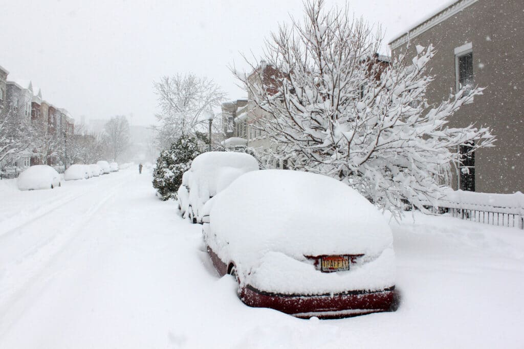 Cars parked in a street covered in snow