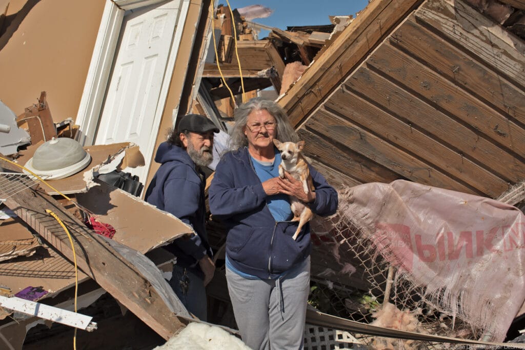 John and Monica Hazen, holding her dog Baby Girl, trying to find cherished belongings at their home in Arabi, Louisiana.
