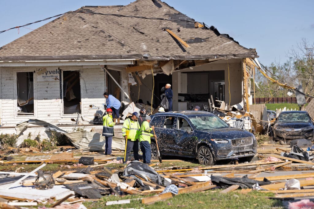 Taran Baker and Anicia Bailey retrieving Baker’s belongings in garbage bags, as officials wait for them to leave after warning them that the structure is not safe to be inside.