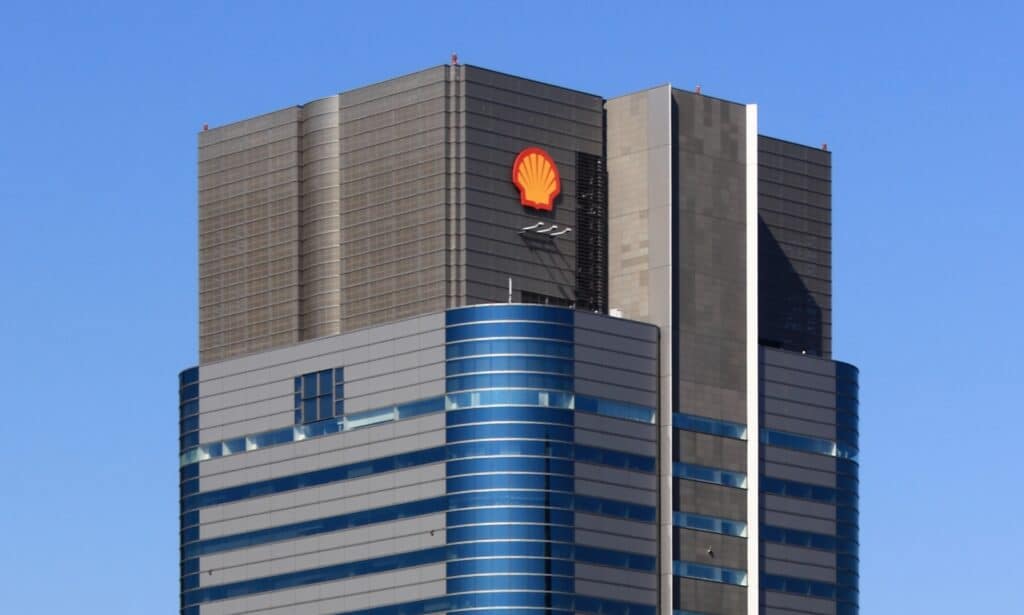 Top of a gray and blue skyscraper with yellow and red shell-shaped Shell oil logo