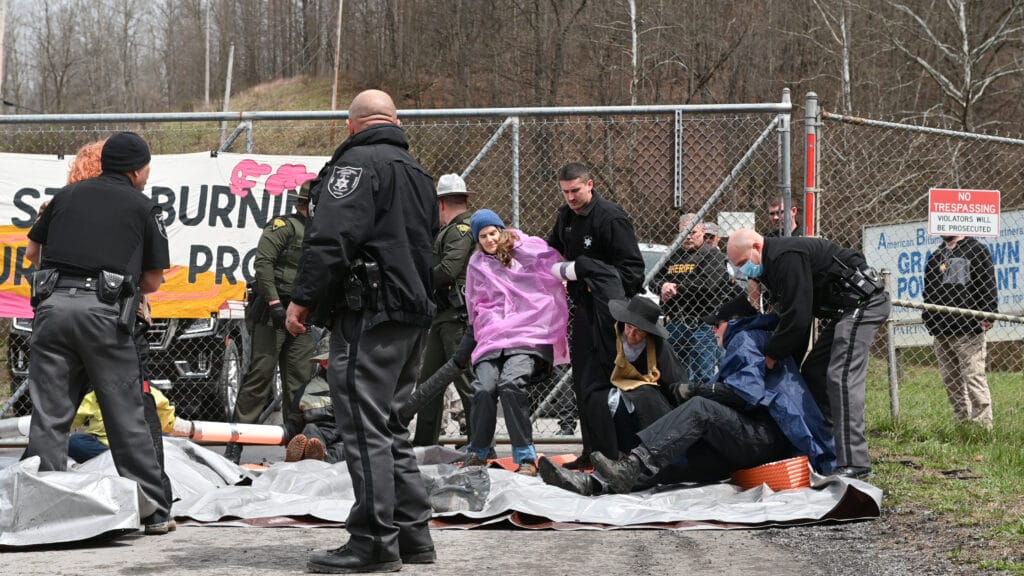 West Virginia Rising protesters, locked together, are pulled to their feet to be arrested by West Virginia state troopers at the Grant Town Power Plant on April 9, 2022.