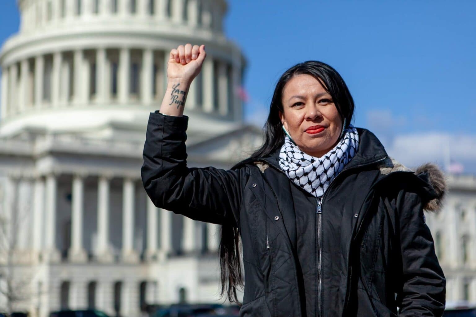 A woman raises a fist in front of the U.S. Capitol