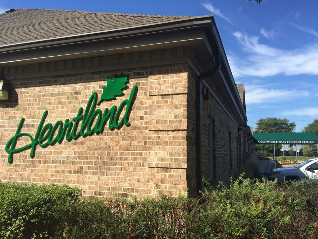 Tan brick one story building with the green logo 'Heartland' with a green lobed oak leaf on the side