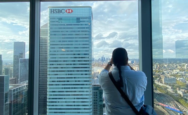 A man looks out the window at an HSBC skyscraper