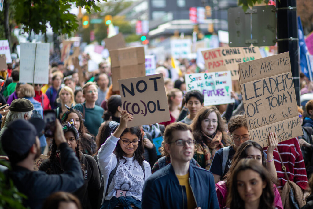 Climate protesters hold up signs and march for climate action in Vancouver, Canada