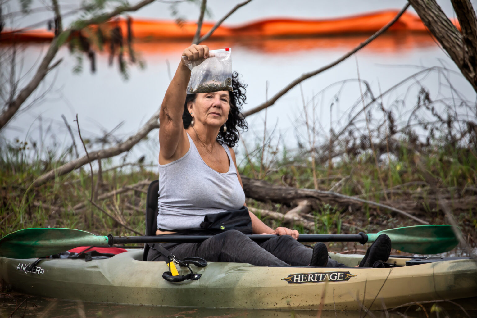Diane Wilson is sitting in a kayak. She holds up a bag full of nurdles - tiny bits of plastic - she collected from one of Formosa’s outfall areas on January 15, 2020.