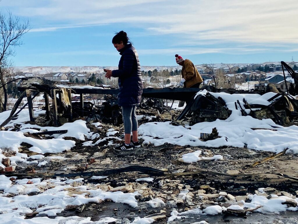 Two homeowners sift through burned debris of home after the Marshall fire