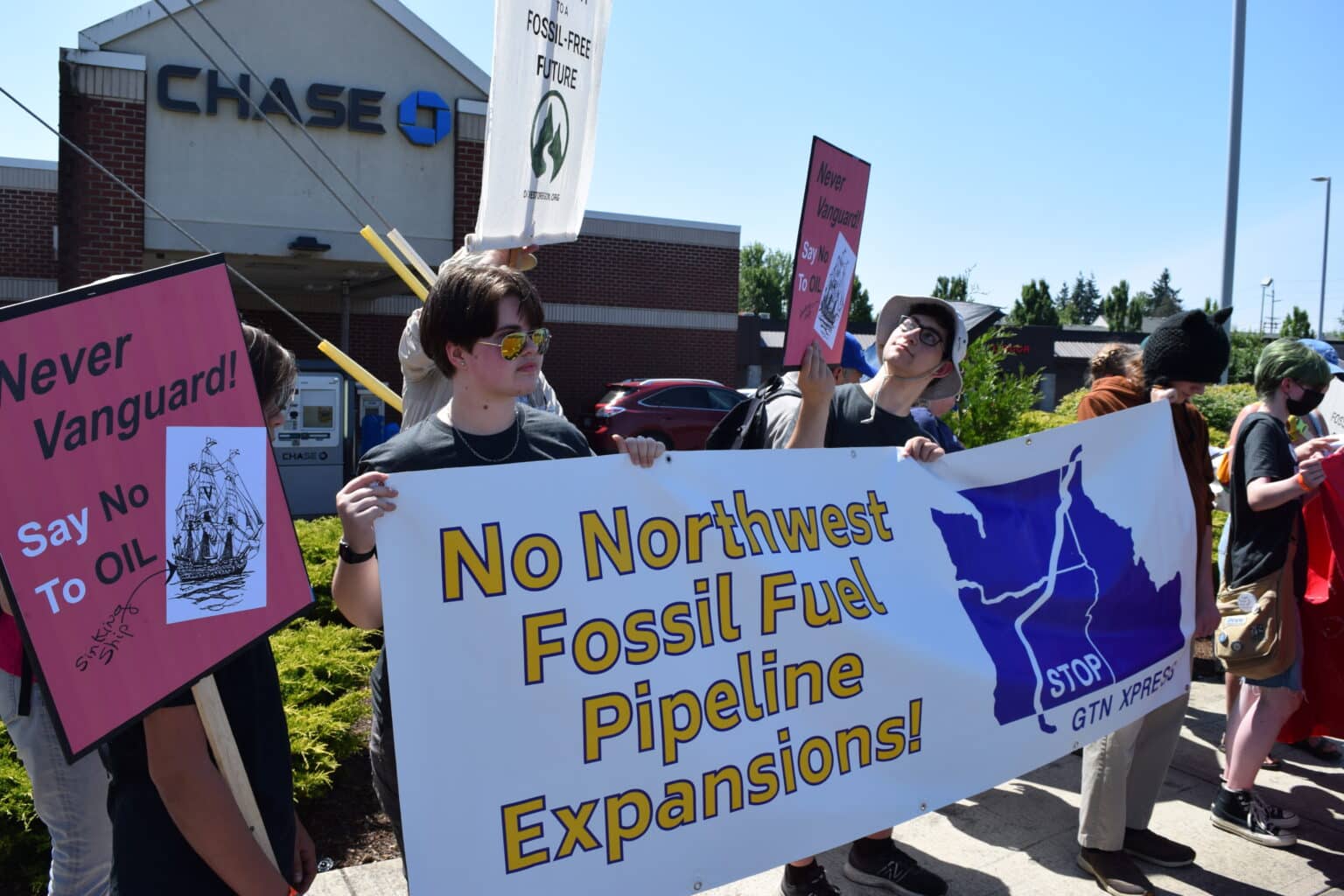Protestors in front of a Chase Bank hold a sign reading "No Northwest Fossil Fuel Pipeline Expansions! Stop GTN Xpress"