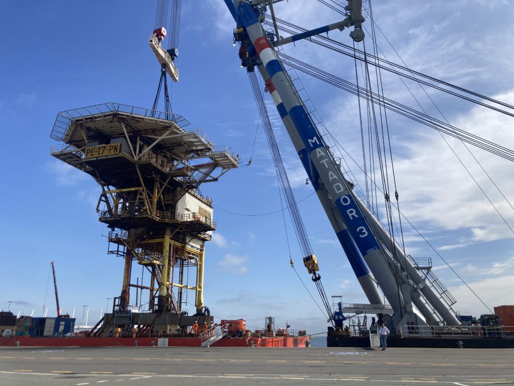 A crane vessel lowering an offshore oil rig onto a quay in the Netherlands.