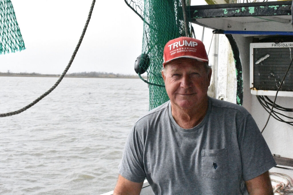 Phillip Dyson, a commercial fisherman, on his fishing boat with the water beyond.