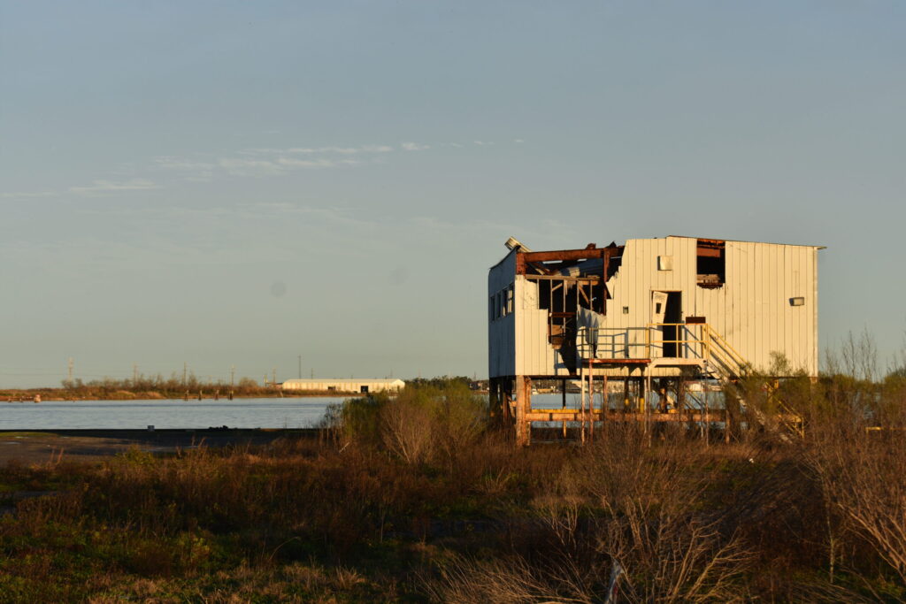 Storm damaged white building on stilts along the Calcasieu River in Louisiana.