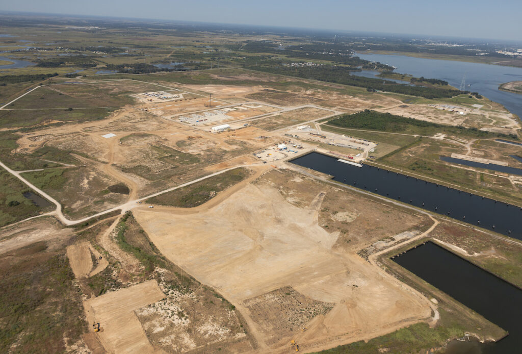 The bare ground outlines and roads of the Driftwood LNG construction site along a shipping channel in Louisiana