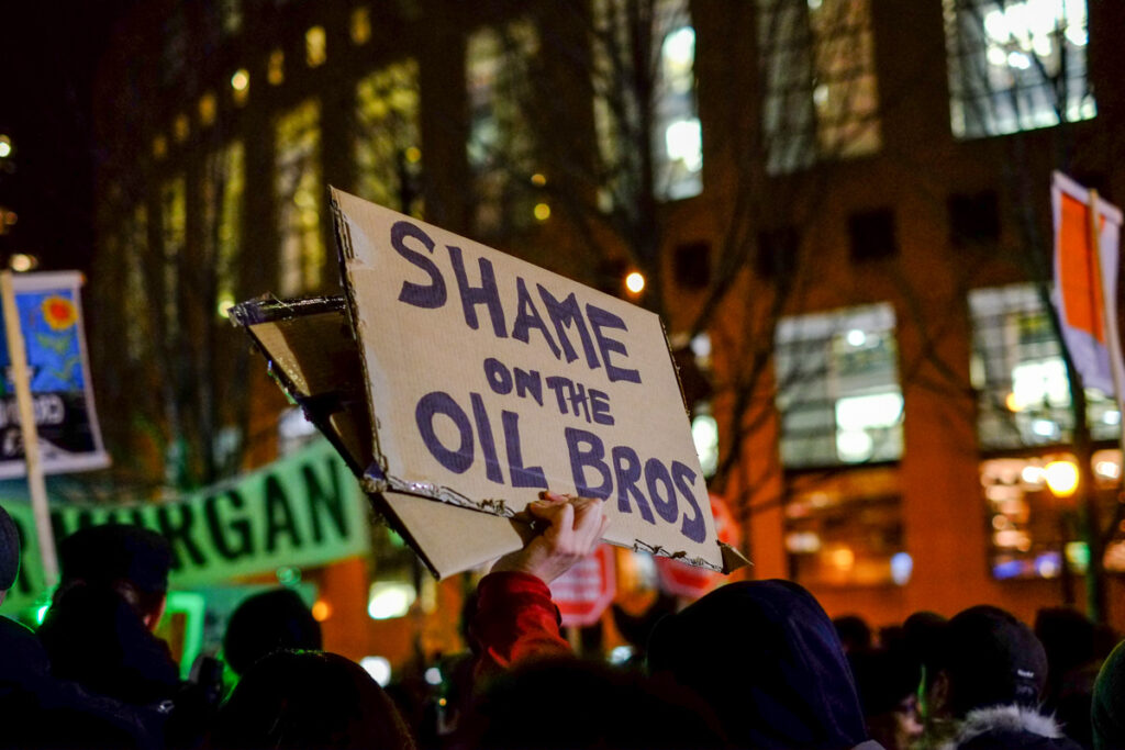 Shame Oil Bros on cardboard sign