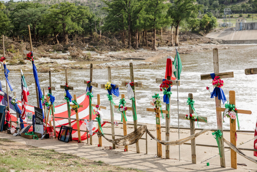 A growing memorial of wooden crosses lines the banks of the Guadalupe River in Kerr County, part of a riverside installation by Dallas artist Roberto Marquez to honor the more than 100 victims of Central Texas’s deadly July 4 flash floods. The crosses — some fashioned from debris swept up by the torrent of the Guadalupe River — stand against the backdrop of its surging waters, the sound of rushing currents filling the air as the community continues to mourn and search for those still missing.