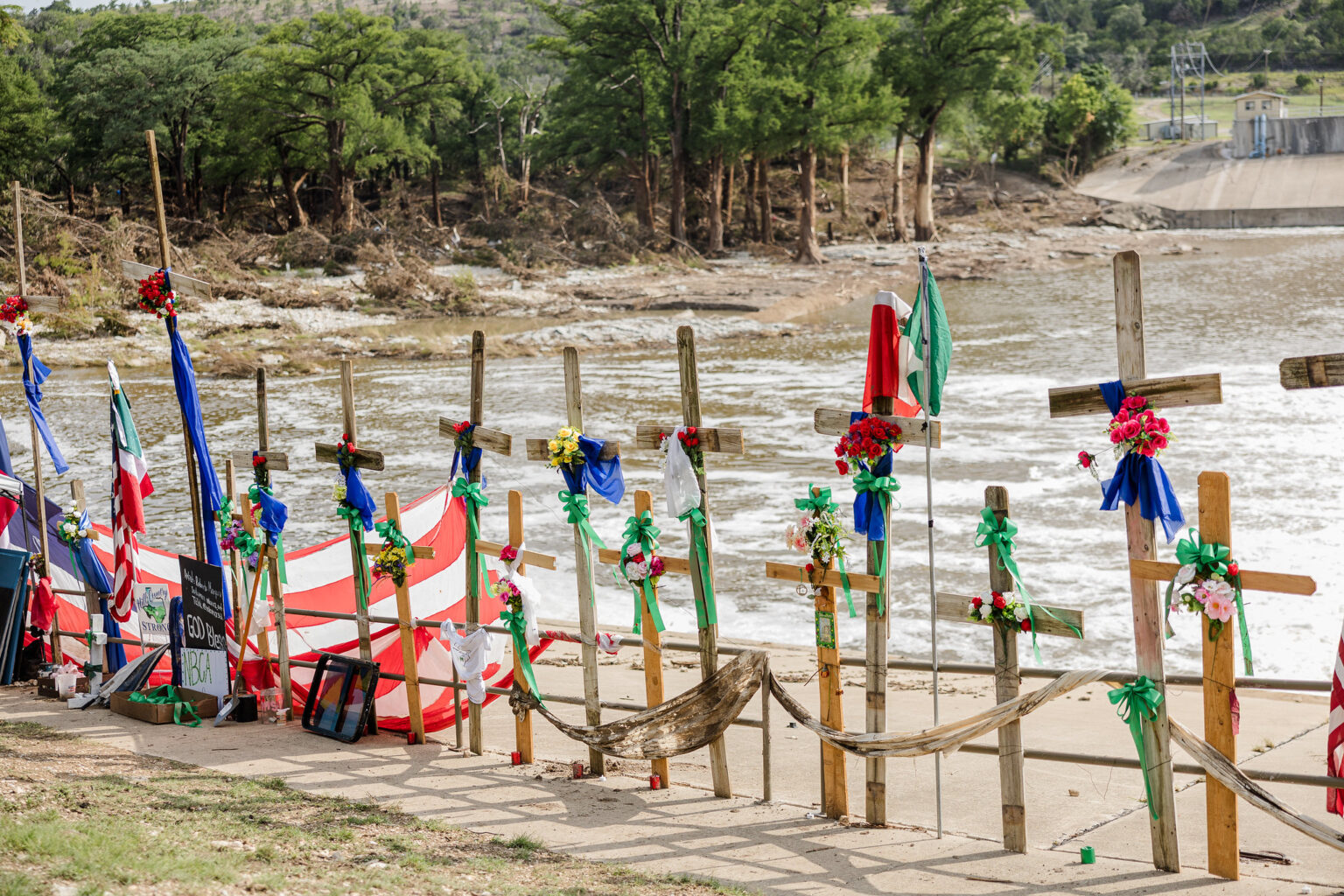 A growing memorial of wooden crosses lines the banks of the Guadalupe River in Kerr County, part of a riverside installation by Dallas artist Roberto Marquez to honor the more than 100 victims of Central Texas’s deadly July 4 flash floods. The crosses — some fashioned from debris swept up by the torrent of the Guadalupe River — stand against the backdrop of its surging waters, the sound of rushing currents filling the air as the community continues to mourn and search for those still missing.