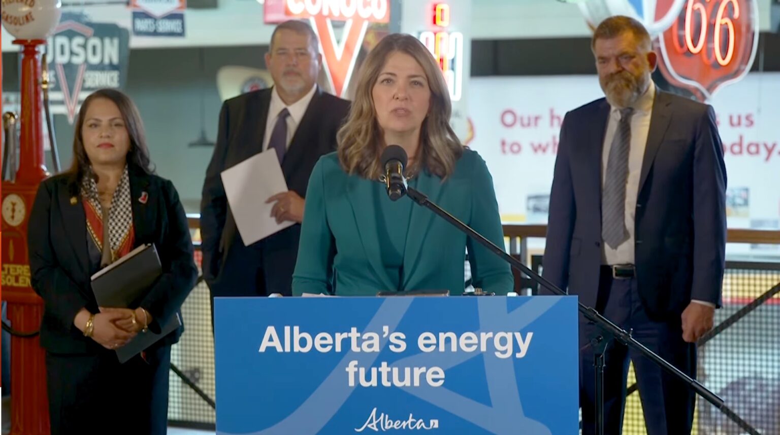 A woman stands in front of a blue podium that says 'Alberta's energy future'