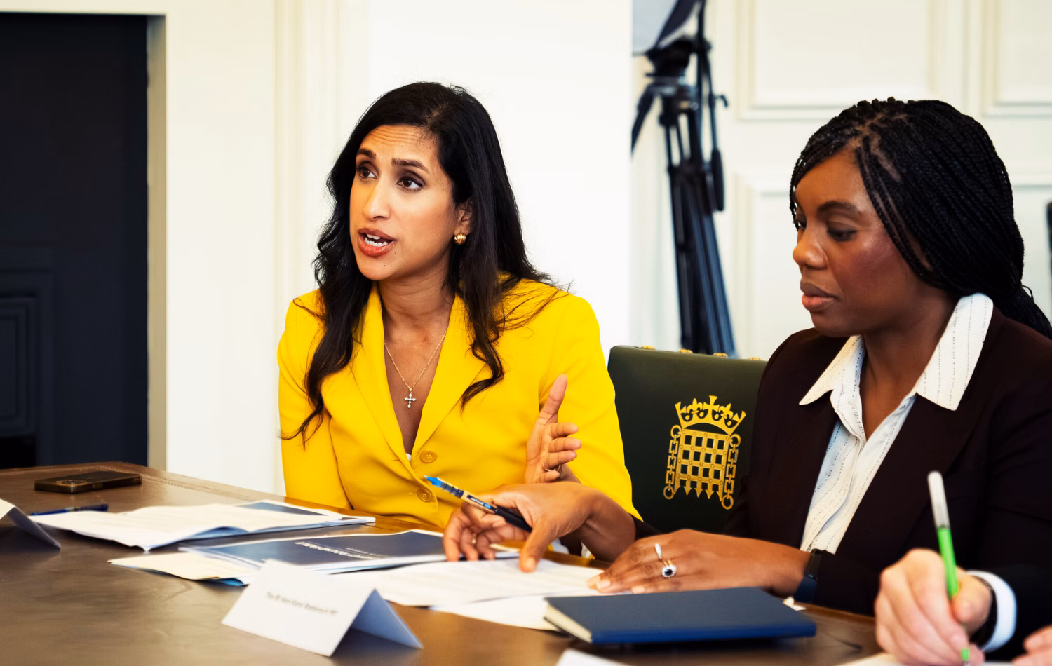 Left, Conservative shadow energy secretary Claire Coutinho, and right, leader Kemi Badenoch sit at a desk..