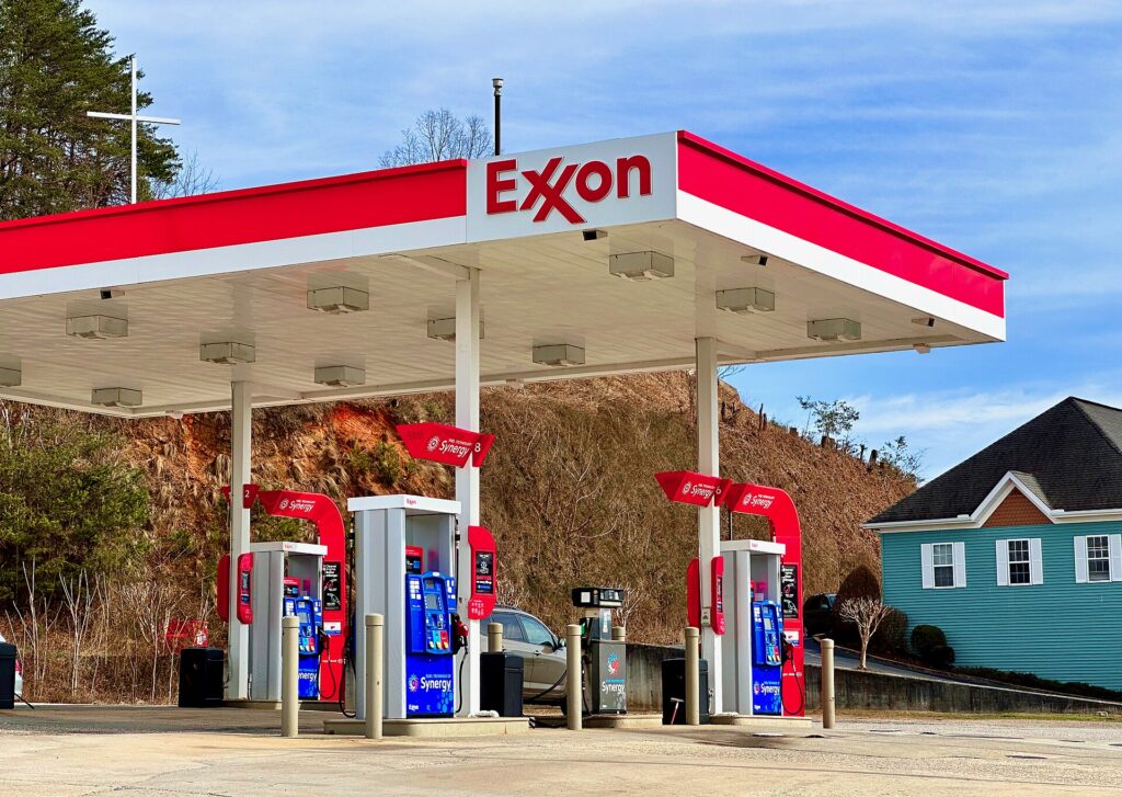 An ExxonMobil gas station in Hiawassee, Georgia, with a blue house in the background.