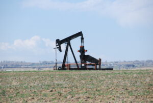 A pumpjack pumps oil in an arid steppe field on the border of Weld and Larimer counties, Colorado.