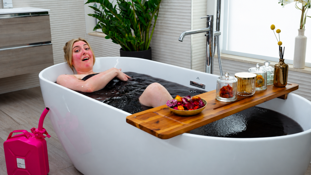Woman happily bathing in a bathtub of crude oil.