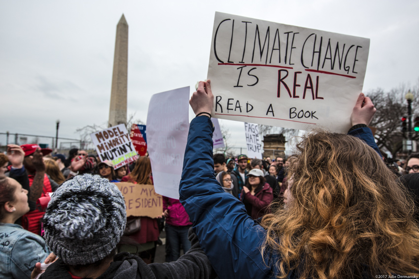 Protest sign reading 'Climate change is real. Read a book' at Donald Trump's inauguration