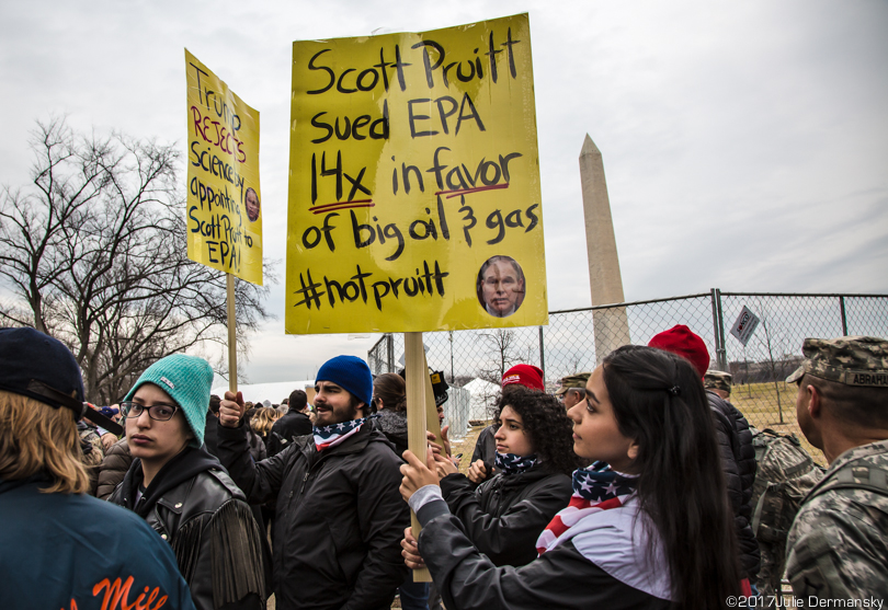 Protesters hold signs disavowing Trump's EPA chief pick, Scott Pruitt.