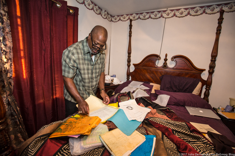 Hilton Kelley tries to salvage paper copies of plays and poems he wrote on the bed of his flooded home