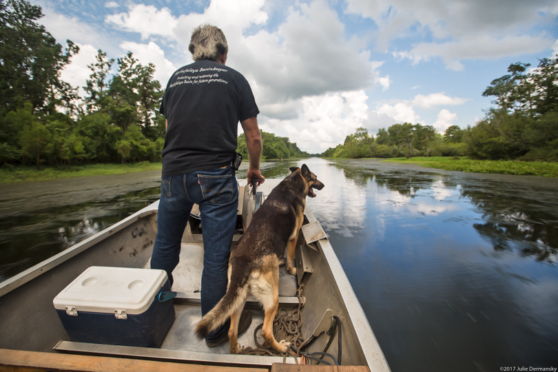 Dean Wilson of the Atchafalaya Basinkeeper and his dog in a boat in the basin