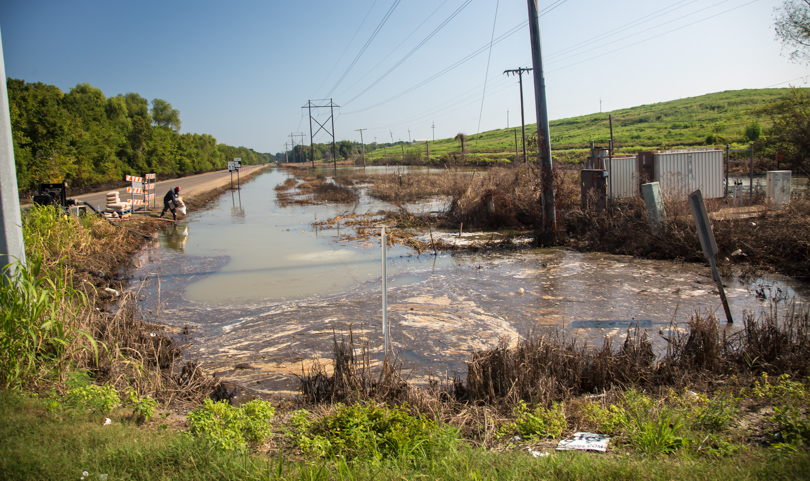 Worker dumping soda ash in contaminated floodwater next to the Honeywell chemical plant in Geismar, Louisiana. 