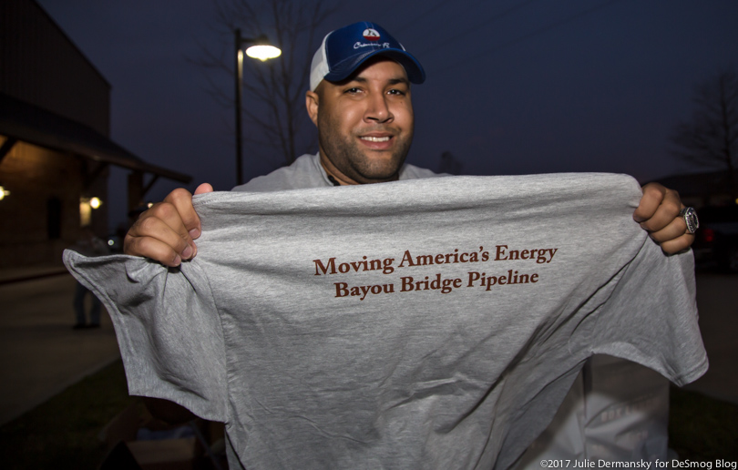 A man holding a t-shirt in support of the Bayou Bridge pipeline