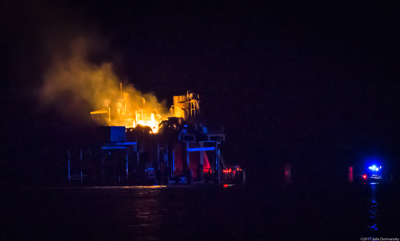 Rescue boat near a fire on the Clovelly oil and gas storage platform on Lake Pontchartrain near Kenner, Louisiana.