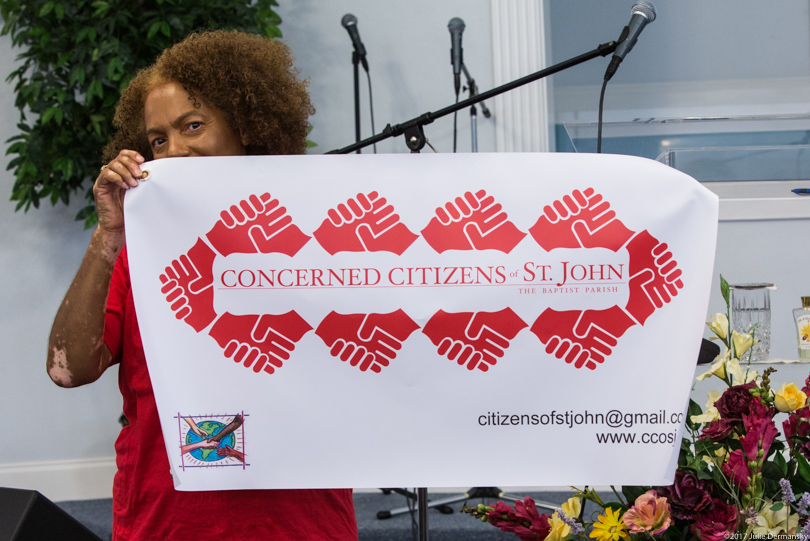 Lydia Gerard holding a new sign for the Concerned Citizens of St. John