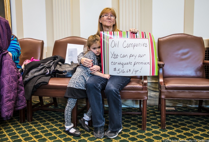 A woman and her granddaughter at a hearing on fracking-induced earthquakes in Oklahoma