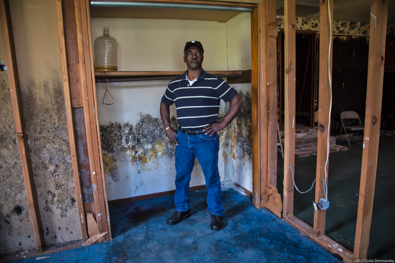 Ervin Coleman stands by the moldy walls of his flood-damaged house in Louisiana
