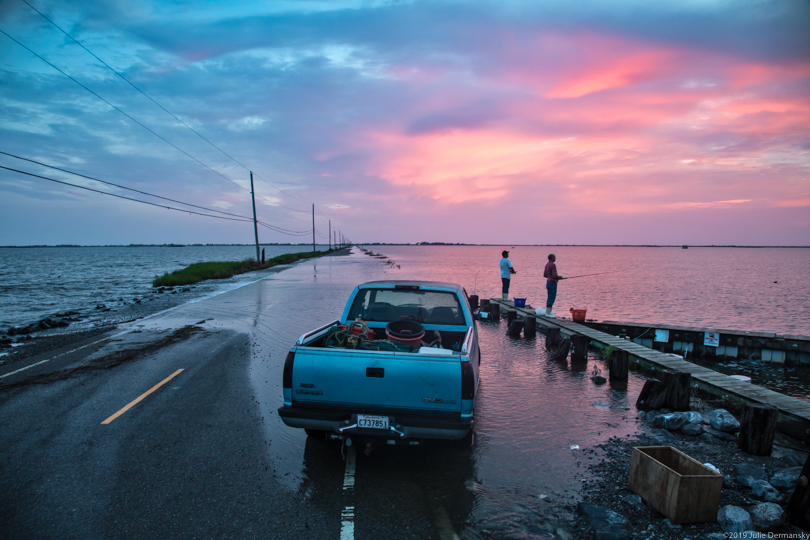 Men fishing off the Isle de Jean Charles' Island Road, flooded from Tropical Storm Barry.