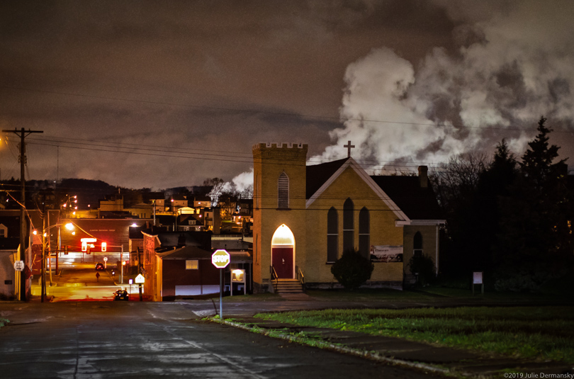 Emissions from the Clairton coking plant rise behind a church near Johnie Perryman's home in Clairton