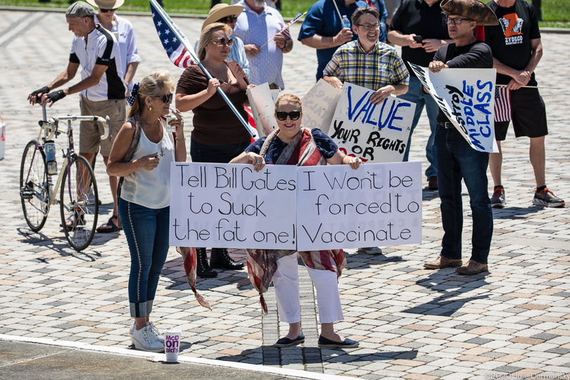 Woman with a COVID-19 denial sign targeting Bill Gates, a common target of the right wing